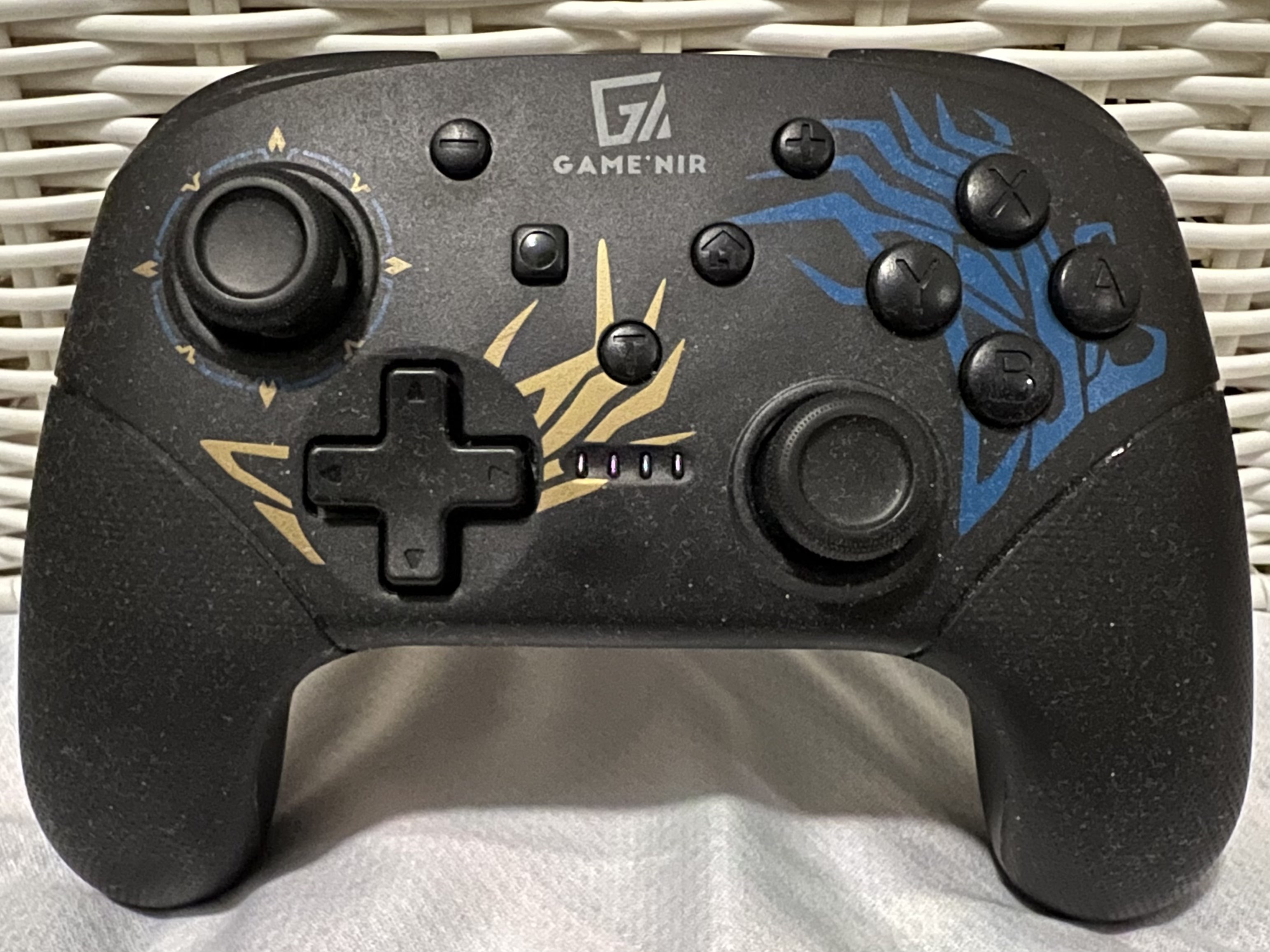 Black controller with gold and blue patterns